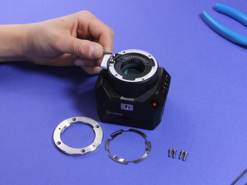 Black plastic mount component being reinstalled
